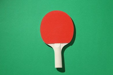 Photo of One ping pong racket on green background, top view