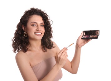Photo of Smiling woman with eyeshadow palette and brush on white background