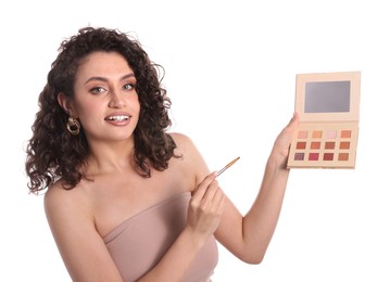 Photo of Woman with eyeshadow palette and brush on white background
