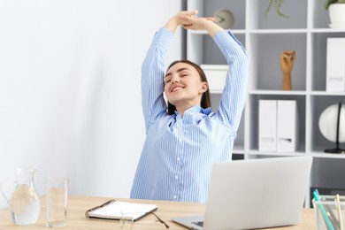 Photo of Beautiful woman stretching on chair in office