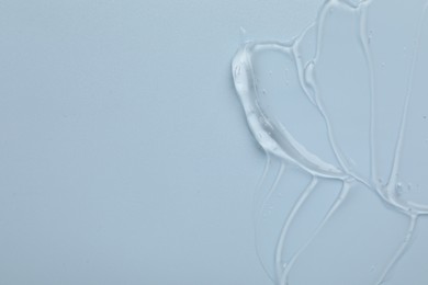 Photo of Collagen gel on light blue background, top view. Space for text