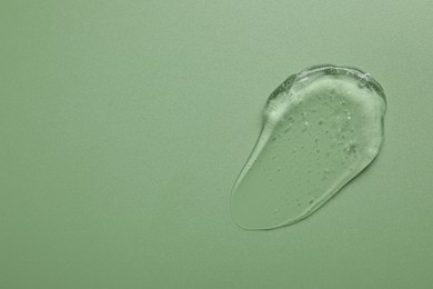 Photo of Collagen gel on green background, top view. Space for text