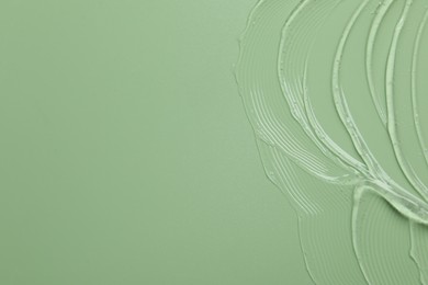 Photo of Collagen gel on green background, top view. Space for text