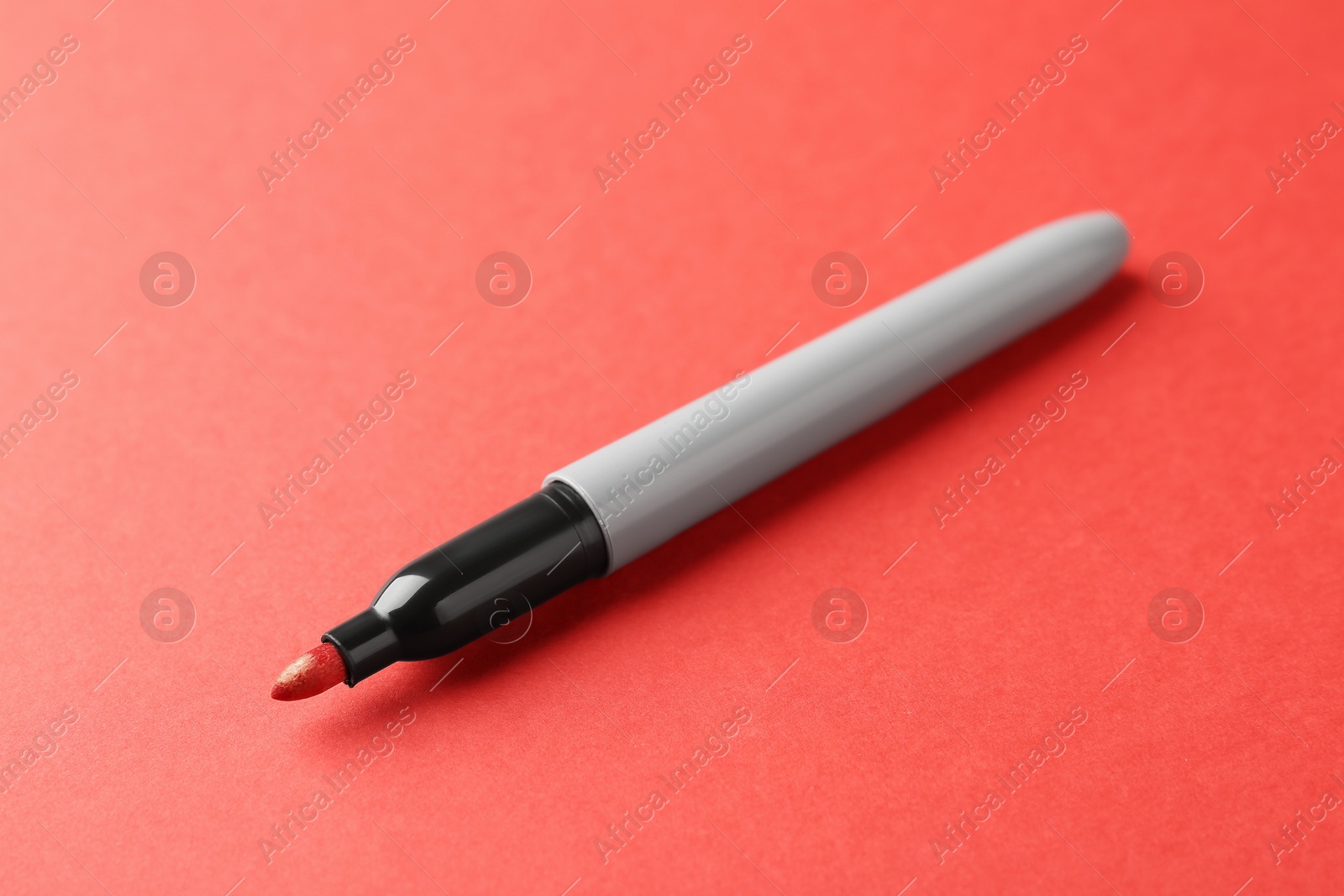 One color marker on red background, closeup. Space for text Photo of One color marker on red background, closeup. Space for text
