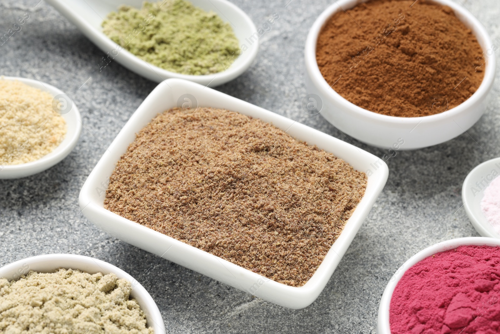 Different superfood powders on grey textured table, closeup Photo of Different superfood powders on grey textured table, closeup