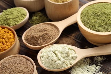 Photo of Different superfood powders on wooden table, closeup
