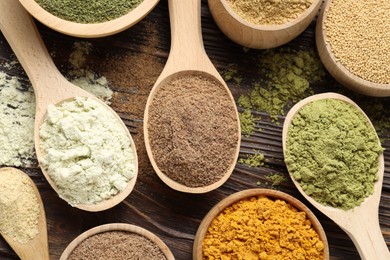 Photo of Different superfood powders on wooden table, flat lay