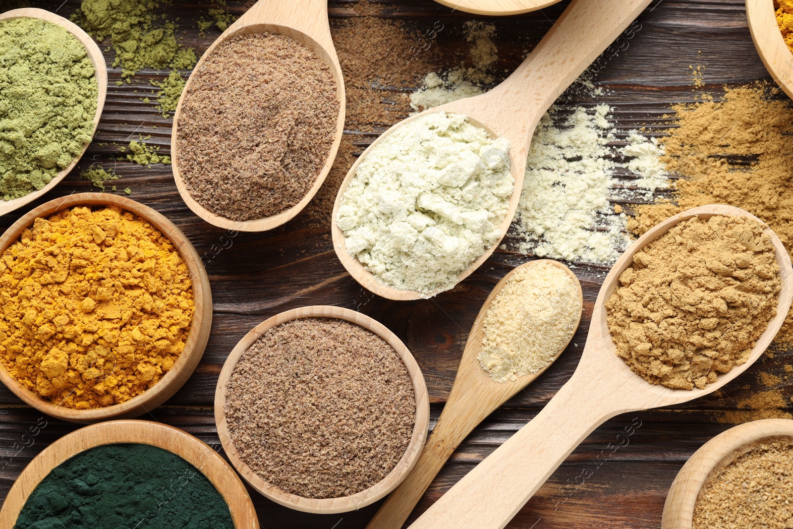 Different superfood powders on wooden table, flat lay Photo of Different superfood powders on wooden table, flat lay