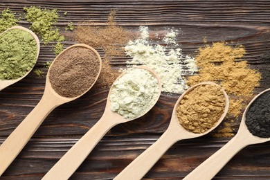 Photo of Different superfood powders and spoons on wooden table, flat lay