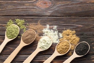 Photo of Different superfood powders and spoons on wooden table, flat lay