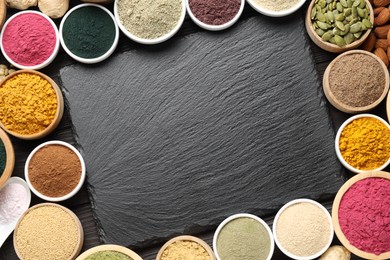 Photo of Different superfood powders and slate board on wooden table, flat lay. Space for text