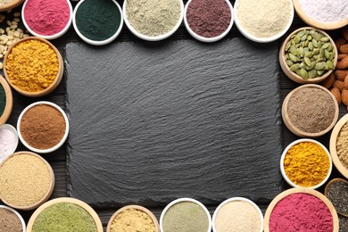 Photo of Different superfood powders and slate board on wooden table, flat lay. Space for text