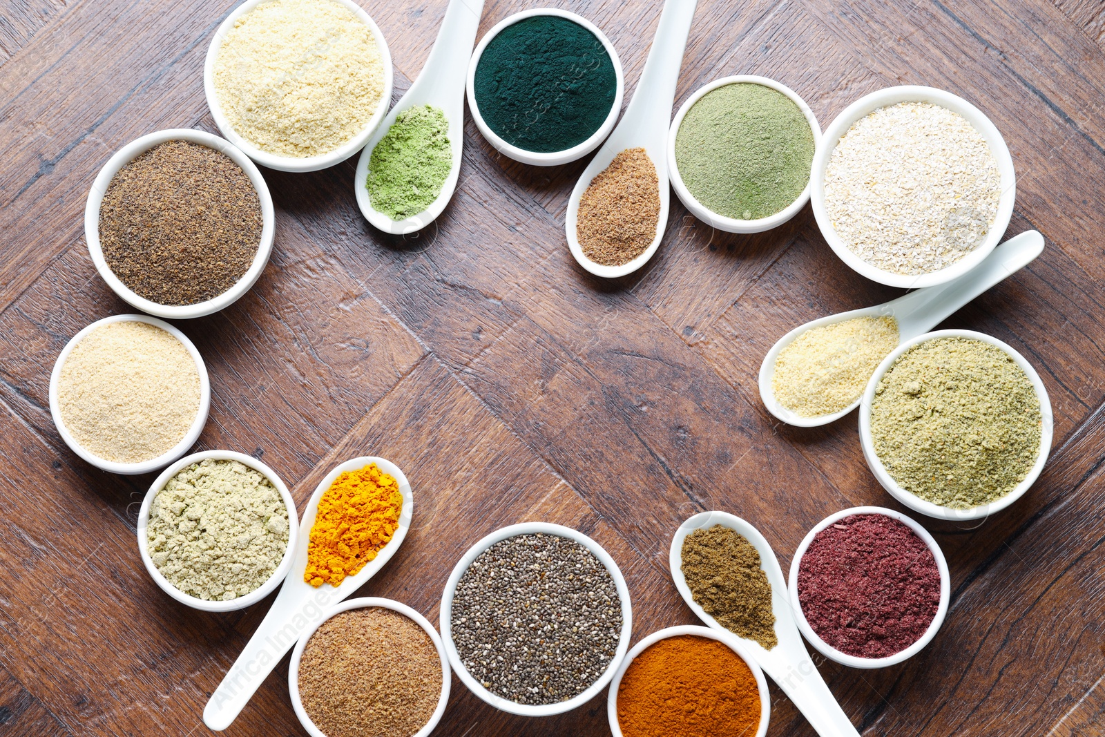 Frame of different superfood powders in bowls and spoons on wooden table, flat lay. Space for text Photo of Frame of different superfood powders in bowls and spoons on wooden table, flat lay. Space for text