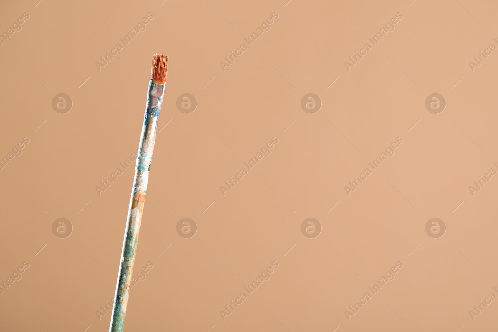 Dirty paintbrush on light brown background, closeup. Space for text Photo of Dirty paintbrush on light brown background, closeup. Space for text