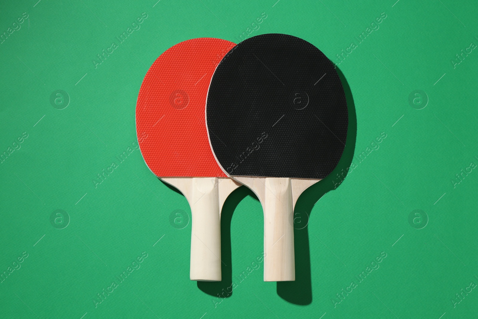 Ping pong rackets on green background, top view Photo of Ping pong rackets on green background, top view