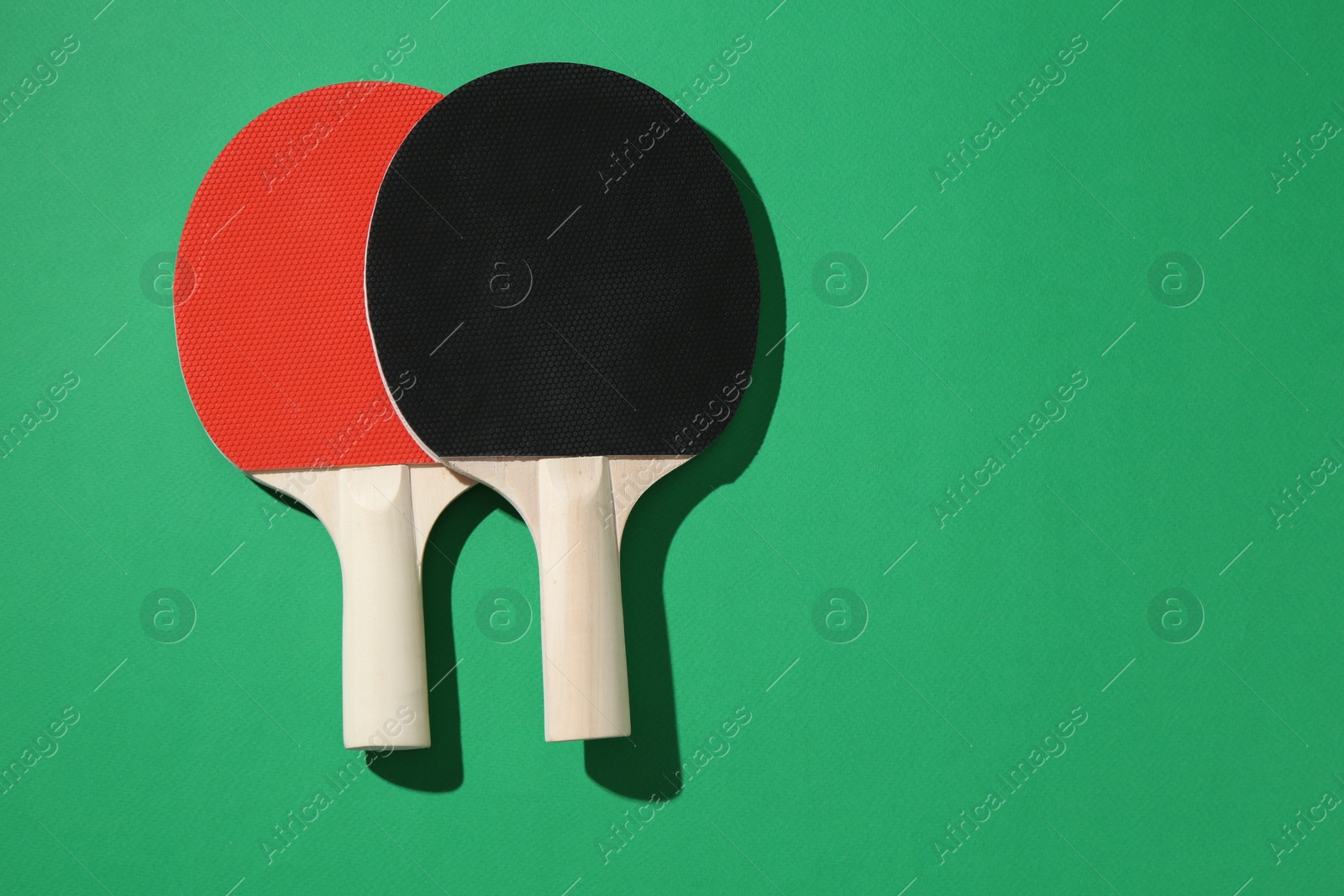 Ping pong rackets on green background, top view. Space for text Photo of Ping pong rackets on green background, top view. Space for text