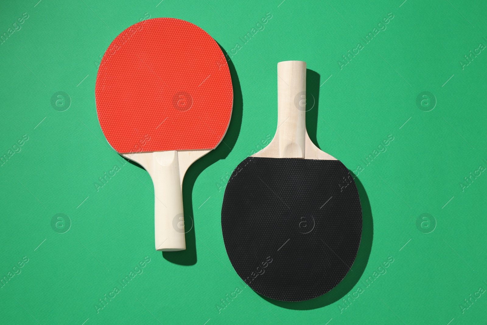 Ping pong rackets on green background, top view Photo of Ping pong rackets on green background, top view
