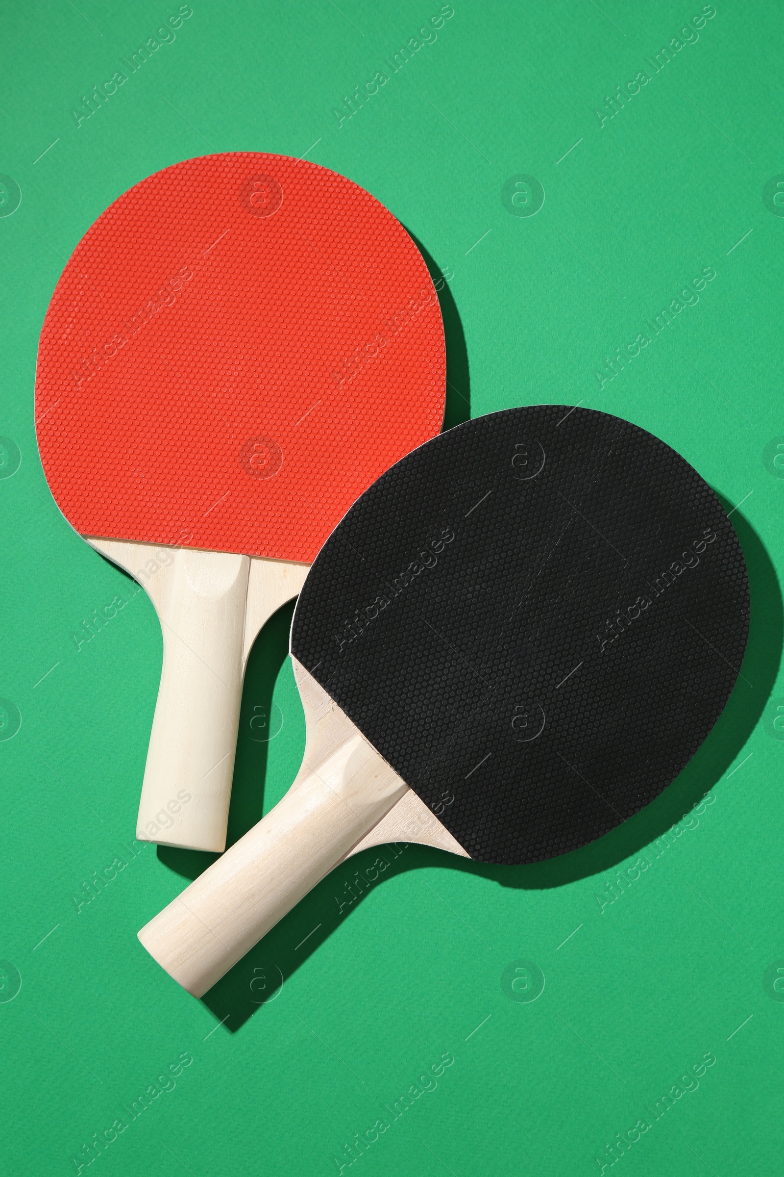 Ping pong rackets on green background, top view Photo of Ping pong rackets on green background, top view