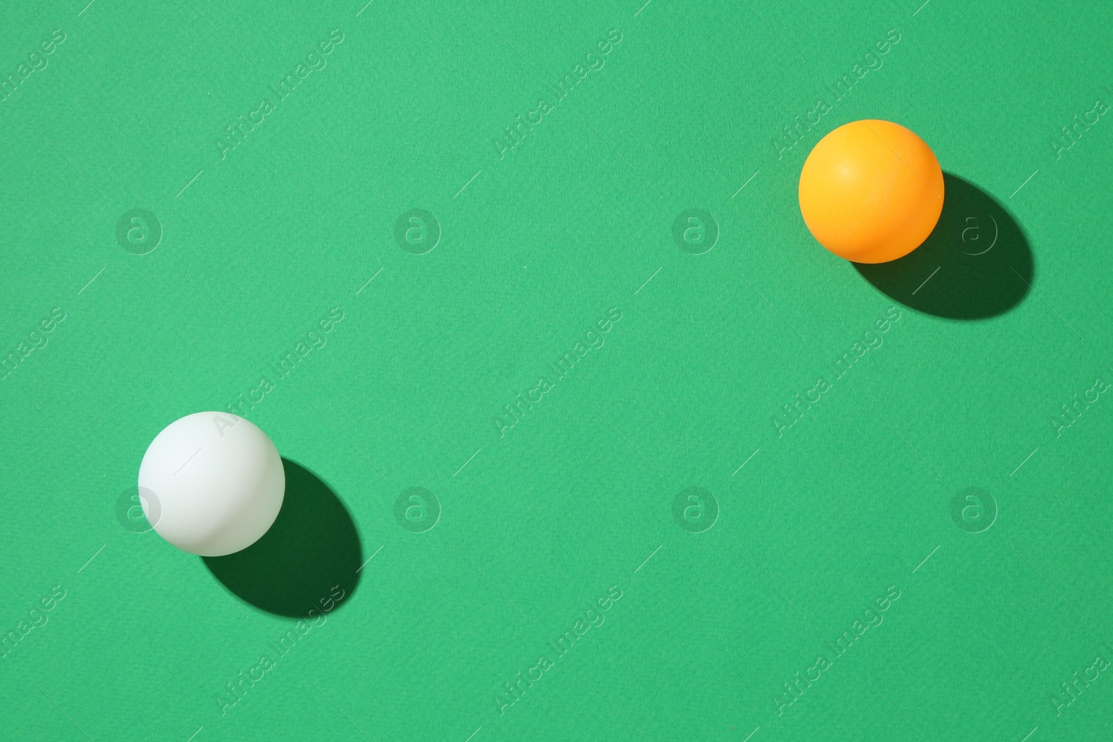 Ping pong balls on green background, top view. Space for text Photo of Ping pong balls on green background, top view. Space for text