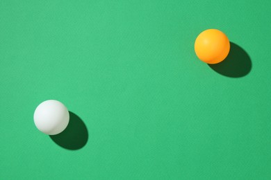Photo of Ping pong balls on green background, top view. Space for text