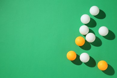 Photo of Ping pong balls on green background, flat lay. Space for text