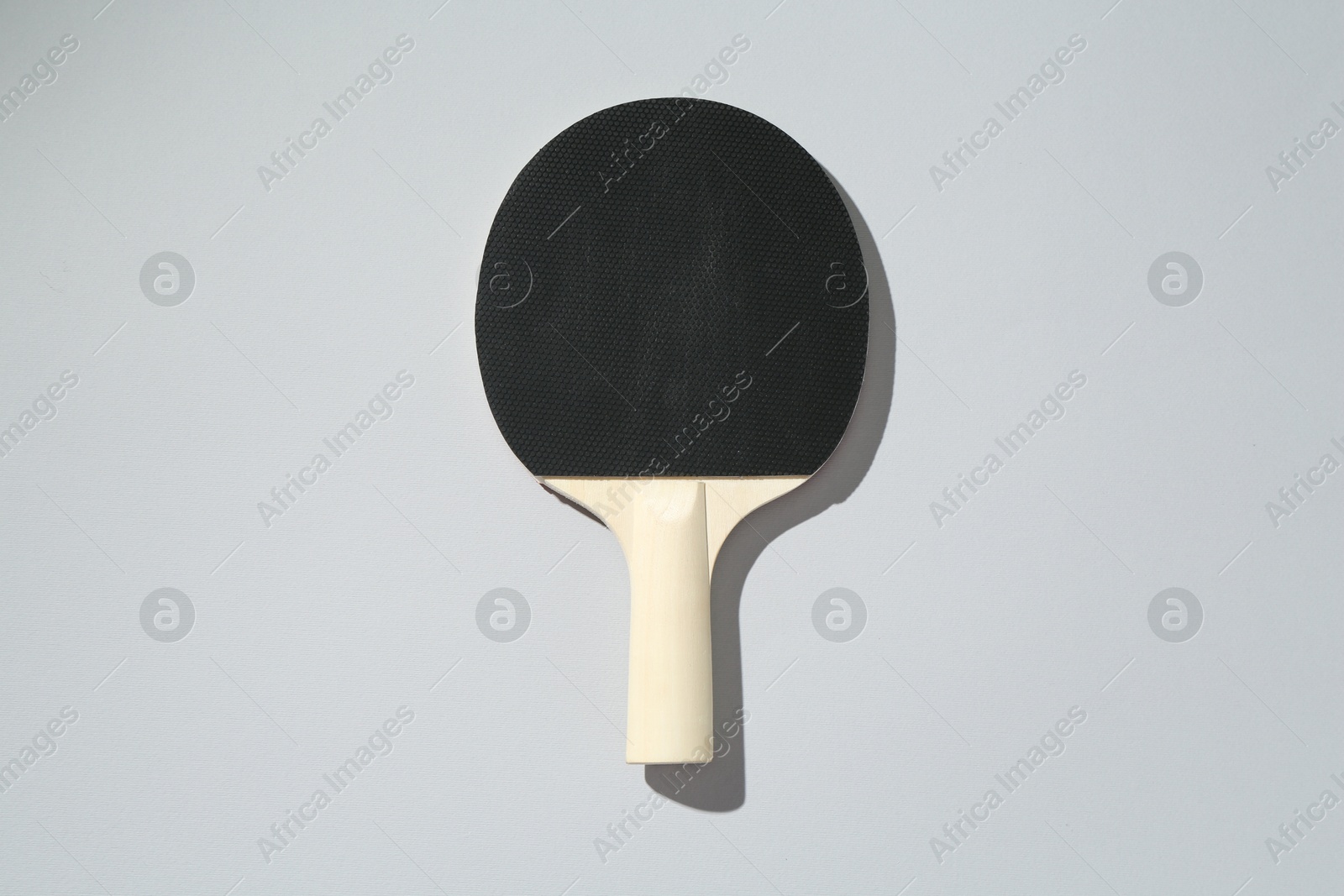 One ping pong racket on light background, top view Photo of One ping pong racket on light background, top view