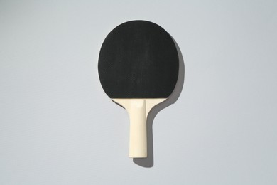 Photo of One ping pong racket on light background, top view