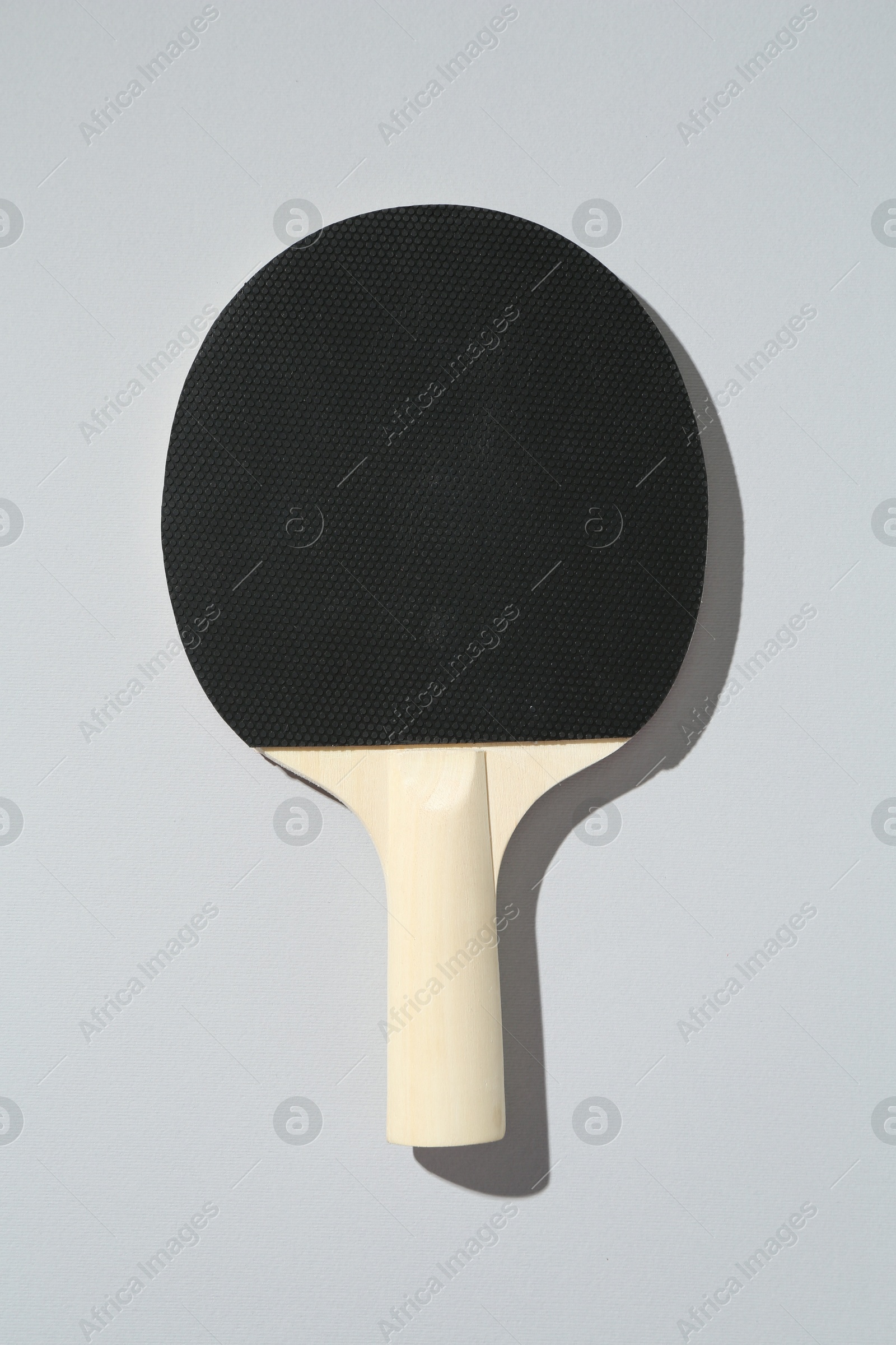 One ping pong racket on light background, top view Photo of One ping pong racket on light background, top view