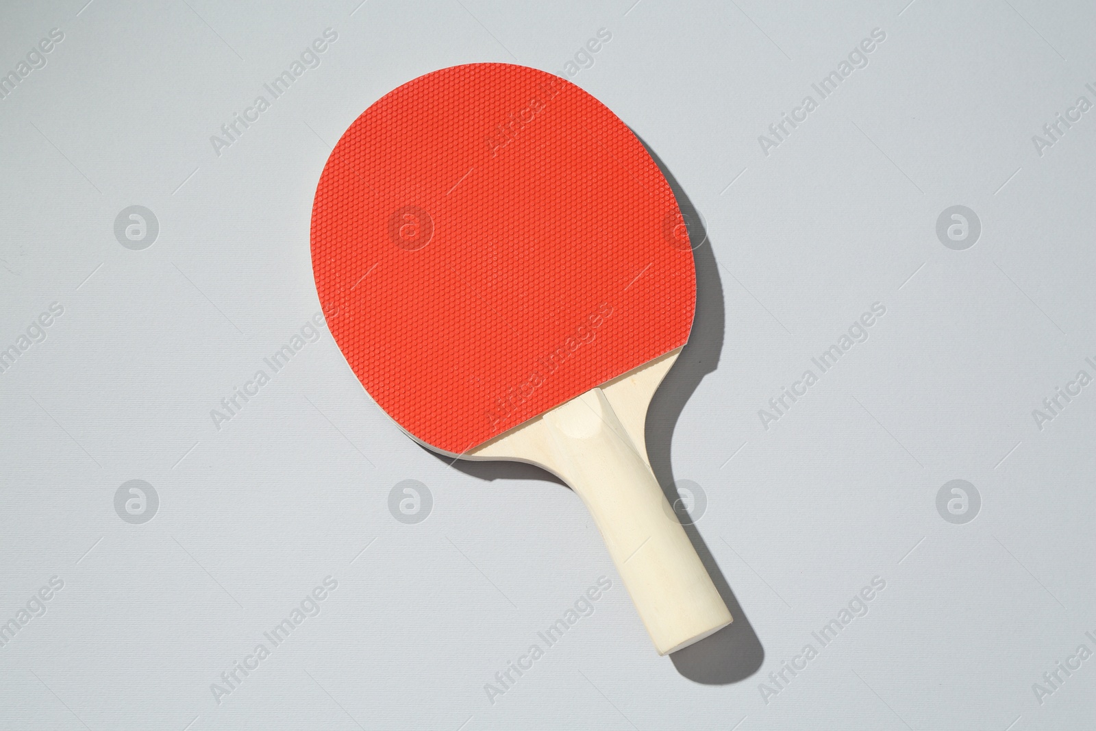 One ping pong racket on light background, top view Photo of One ping pong racket on light background, top view