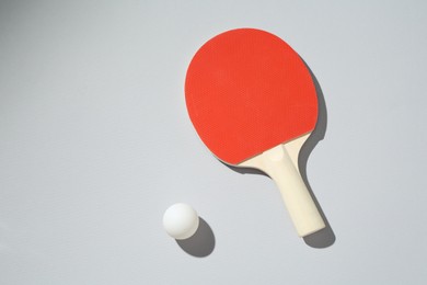 Photo of Ping pong racket and ball on light background, top view