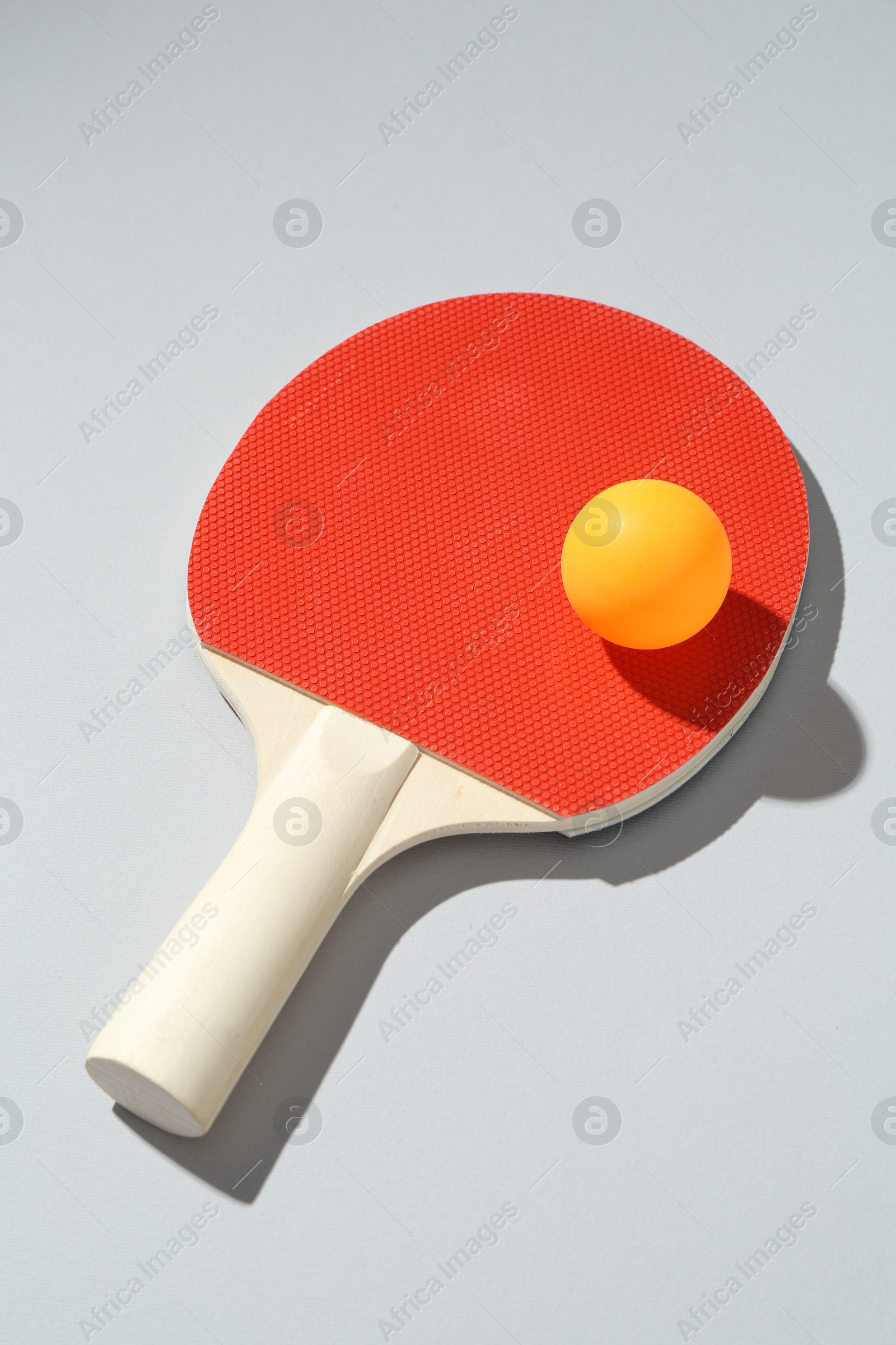Ping pong racket and ball on light background Photo of Ping pong racket and ball on light background