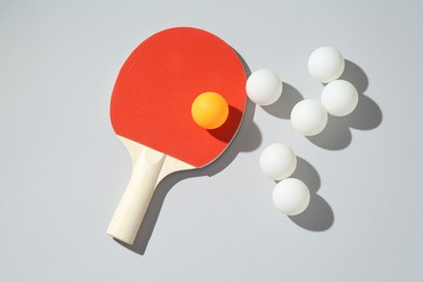 Photo of Ping pong racket and balls on light background, flat lay