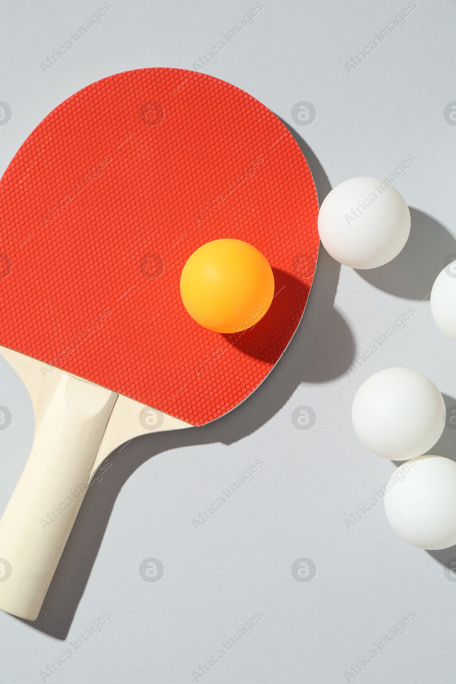 Ping pong racket and balls on light background, flat lay Photo of Ping pong racket and balls on light background, flat lay