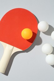 Photo of Ping pong racket and balls on light background, flat lay