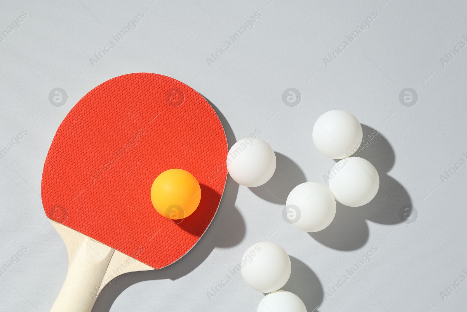 Ping pong racket and balls on light background, flat lay Photo of Ping pong racket and balls on light background, flat lay
