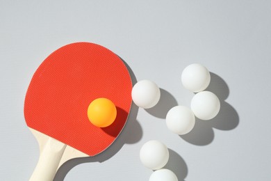 Photo of Ping pong racket and balls on light background, flat lay
