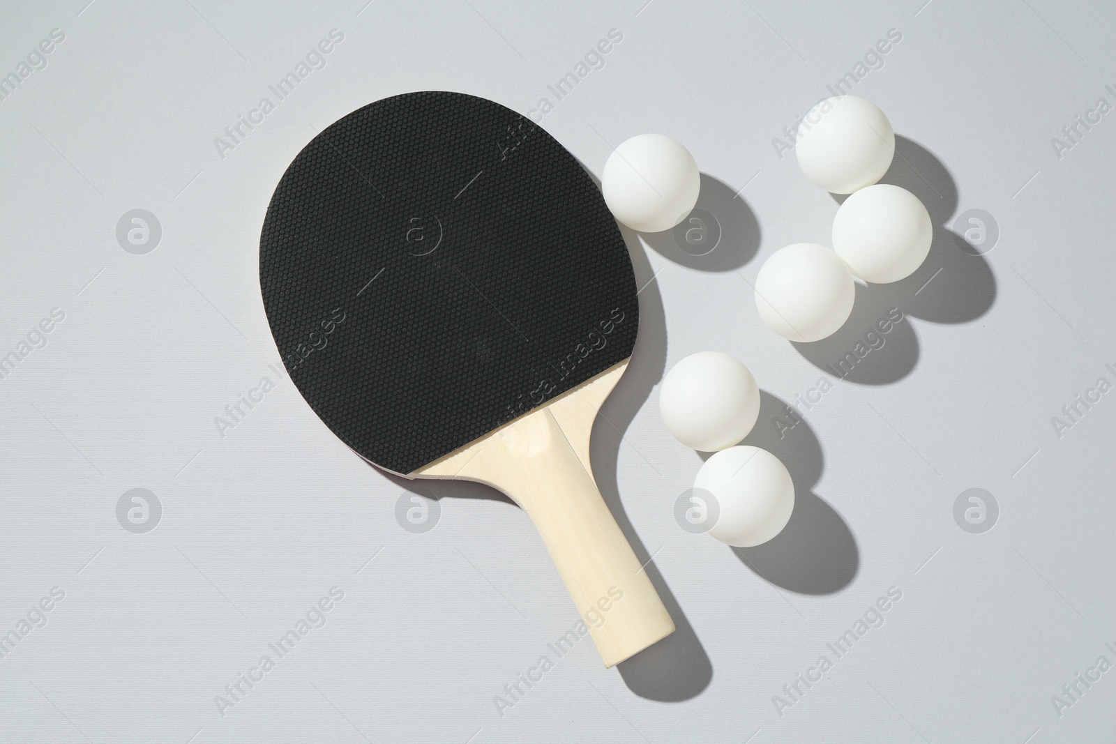 Ping pong racket and balls on light background, flat lay Photo of Ping pong racket and balls on light background, flat lay
