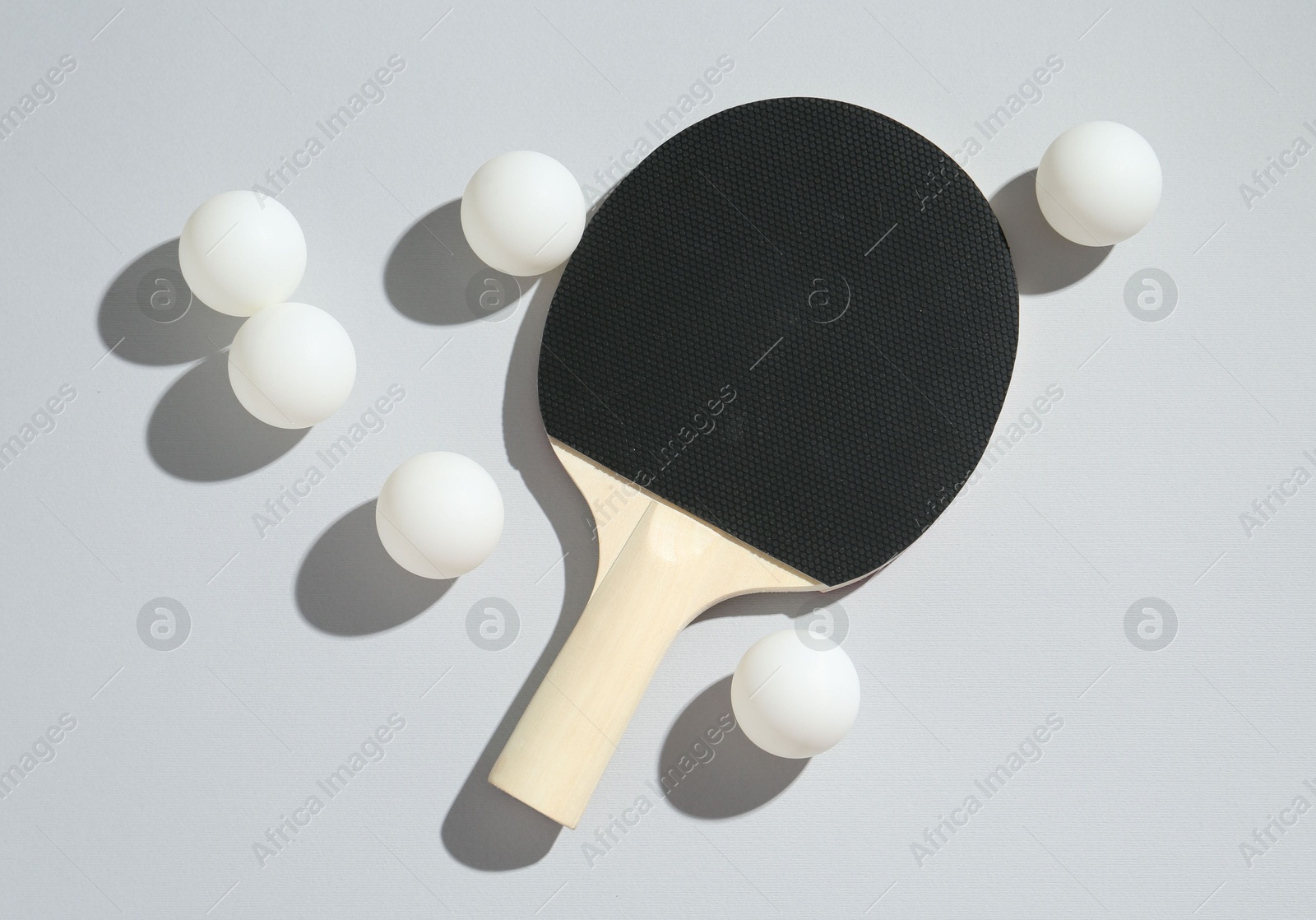 Ping pong racket and balls on light background, flat lay Photo of Ping pong racket and balls on light background, flat lay