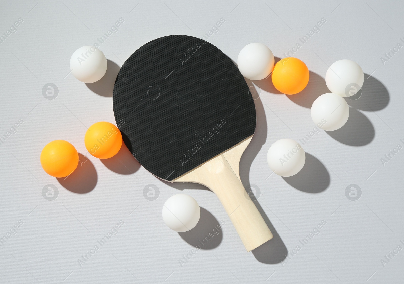 Ping pong racket and balls on light background, flat lay Photo of Ping pong racket and balls on light background, flat lay