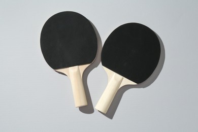 Photo of Ping pong rackets on light background, top view