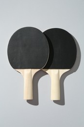 Photo of Ping pong rackets on light background, top view