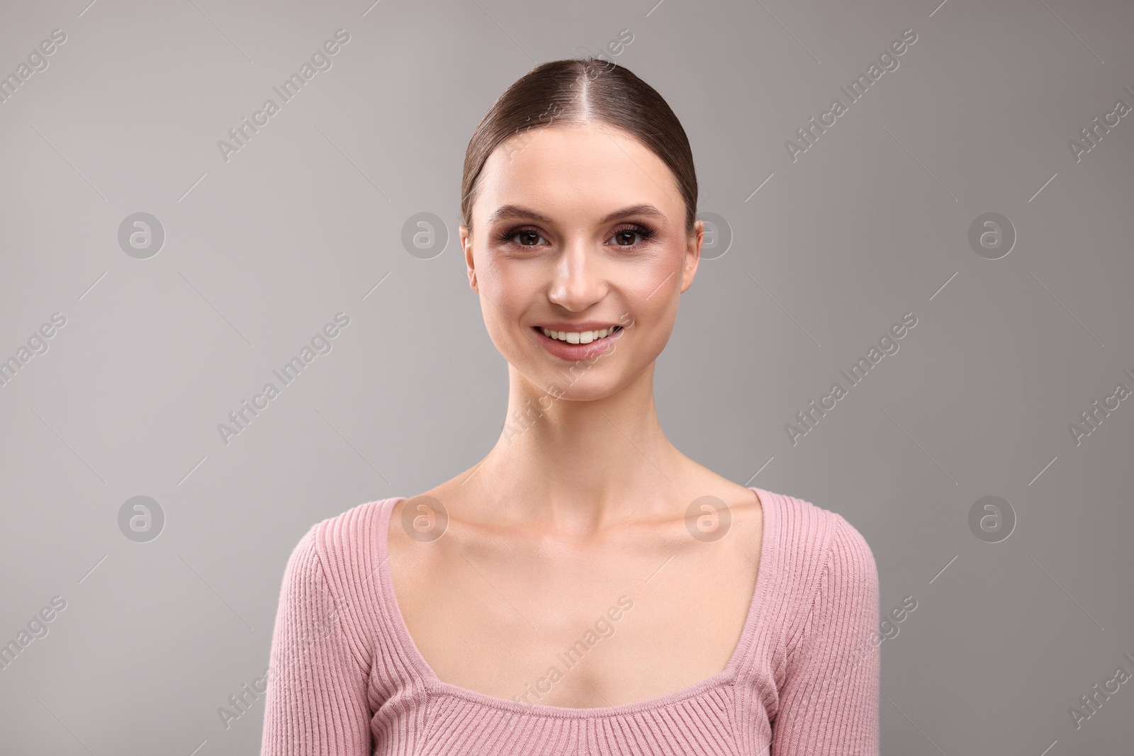 Portrait of beautiful young woman on gray background Photo of Portrait of beautiful young woman on gray background