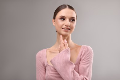 Photo of Portrait of beautiful young woman on gray background