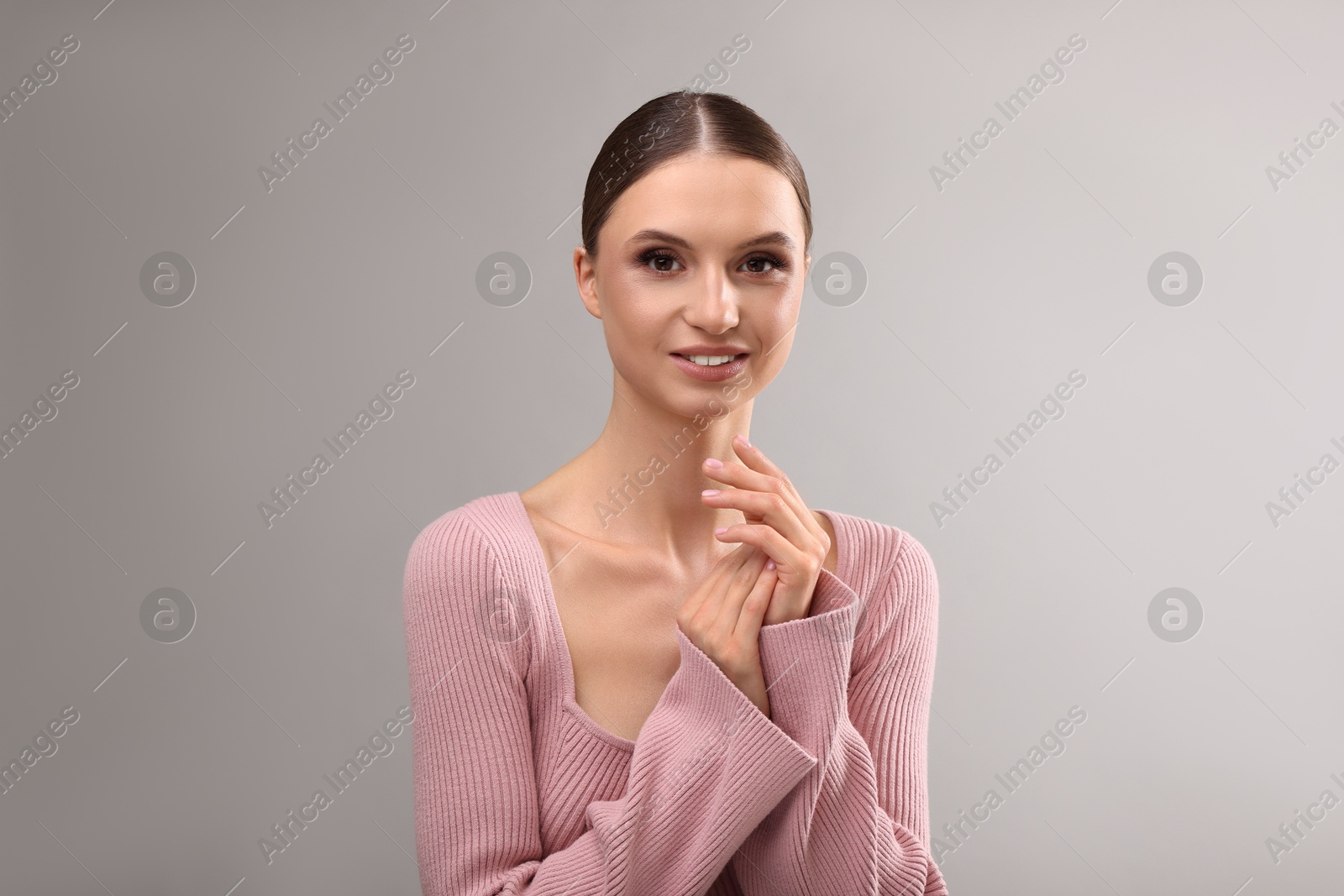 Portrait of beautiful young woman on gray background Photo of Portrait of beautiful young woman on gray background