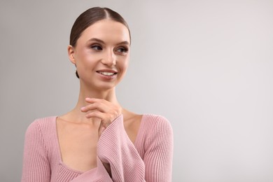 Photo of Portrait of beautiful young woman on gray background, space for text