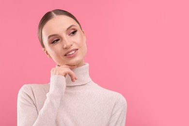 Photo of Portrait of beautiful young woman on pink background, space for text