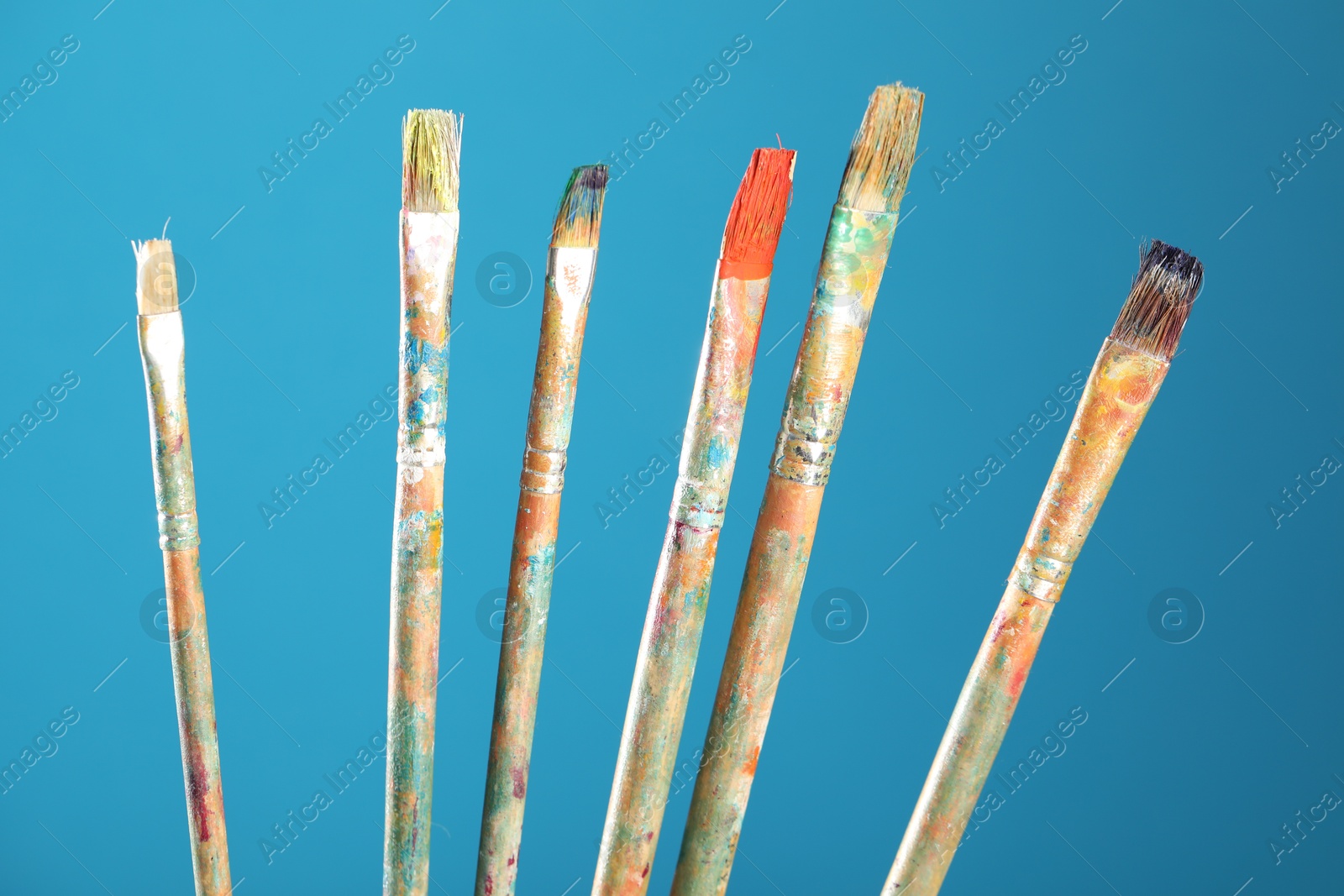 Dirty paintbrushes on light blue background, closeup Photo of Dirty paintbrushes on light blue background, closeup