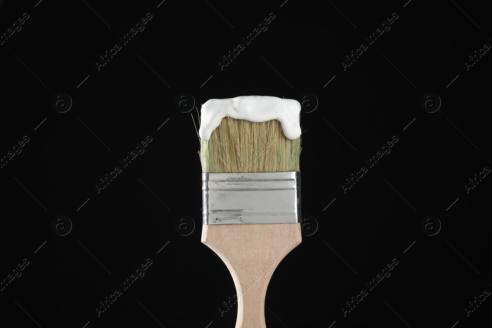 Brush with white paint on black background, closeup Photo of Brush with white paint on black background, closeup