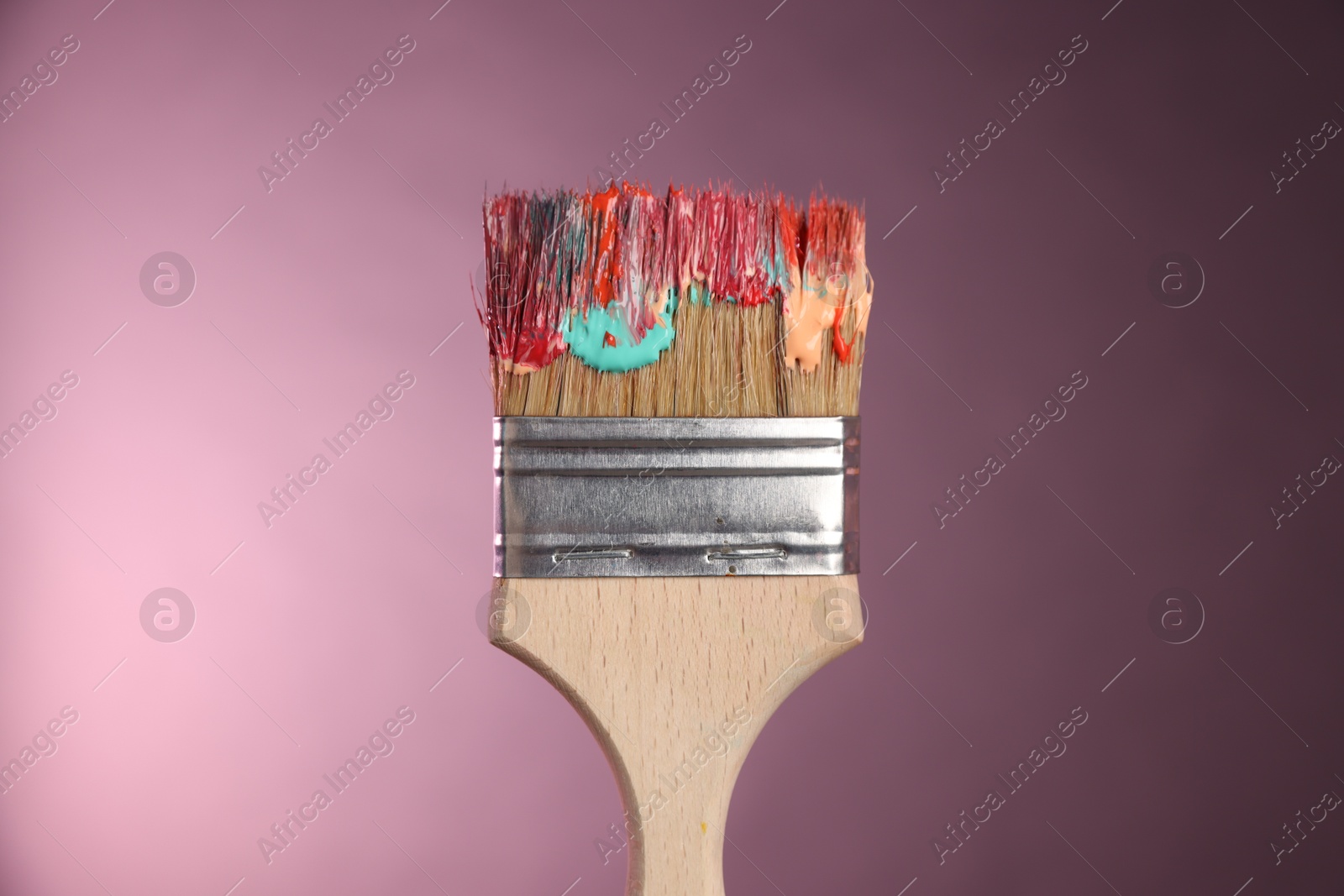One dirty paintbrush on pink background, closeup Photo of One dirty paintbrush on pink background, closeup