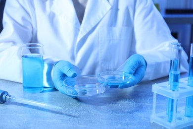 Photo of Scientist with Petri dishes at table, closeup